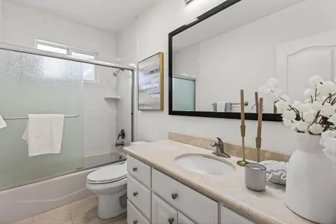 a bathroom with a granite countertop sink a toilet and a mirror