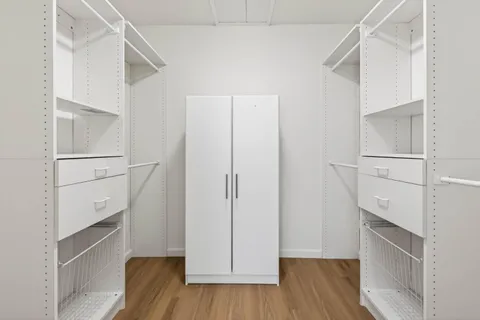 a view of walk in closet with empty racks