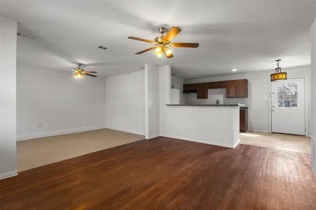a view of a kitchen with wooden floor and a ceiling fan