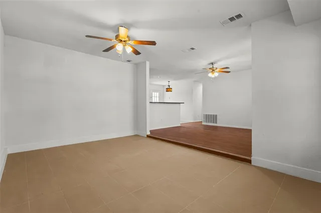 a view of a room with a ceiling fan and window