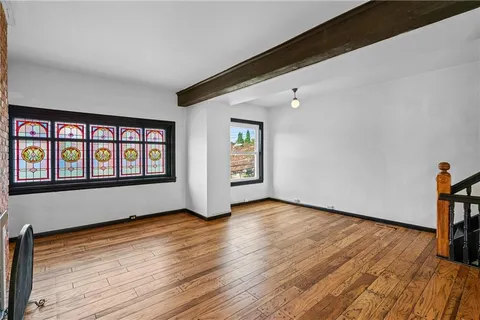 a view of a livingroom with wooden floor and a ceiling fan