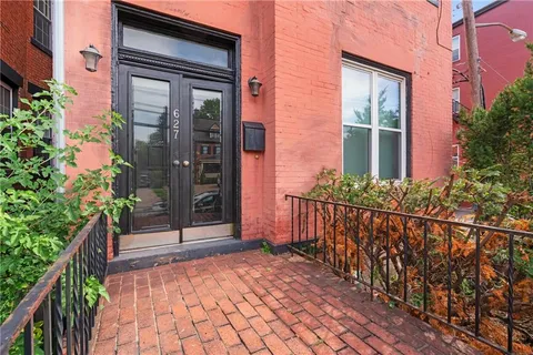 a view of kitchen with stainless steel appliances wooden floor and living room