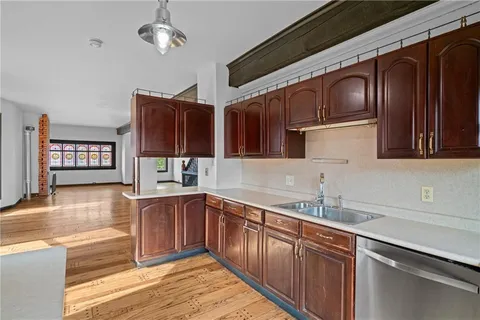 a kitchen with stainless steel appliances granite countertop a refrigerator a sink dishwasher a oven with wooden cabinets and floor