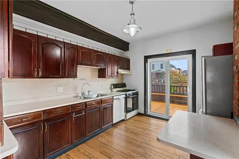 a kitchen with stainless steel appliances granite countertop a stove refrigerator and cabinets