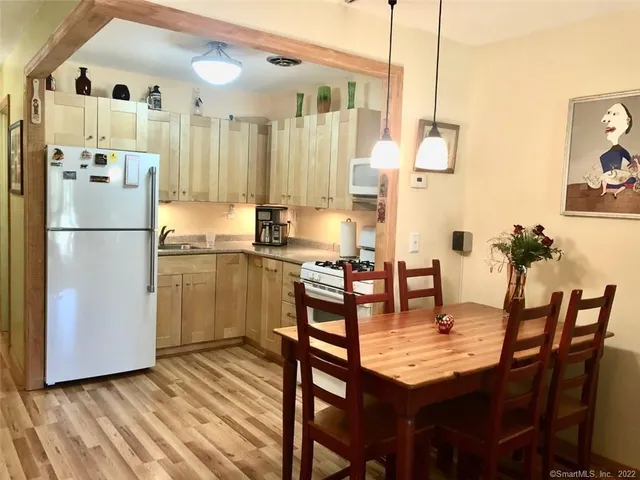 a kitchen with a table chairs refrigerator and cabinets