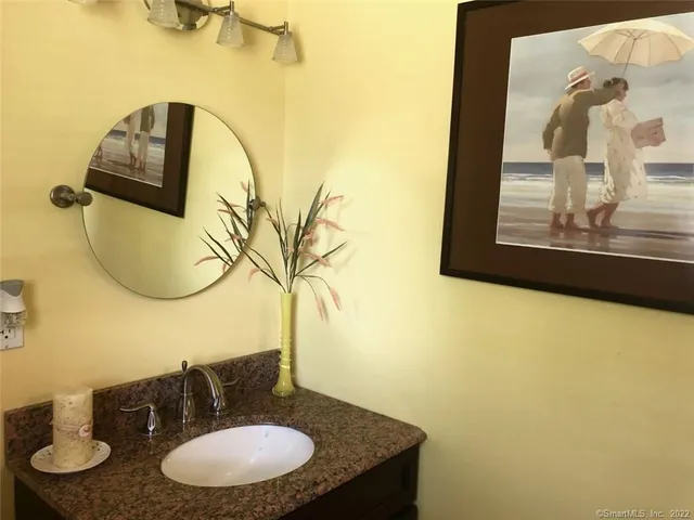 a bathroom with a granite countertop sink and a mirror