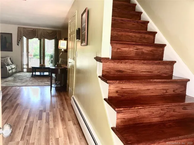 a view of entryway and hall with wooden floor