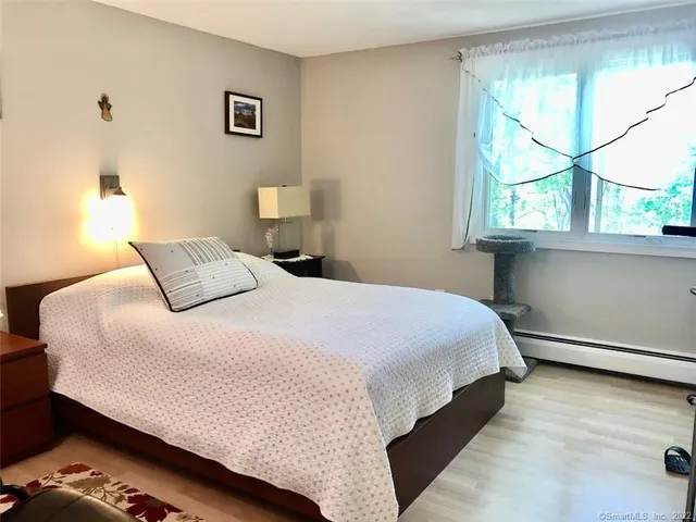 a bedroom with a bed and a large window