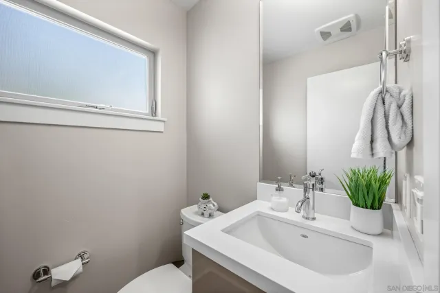 a bathroom with a sink a toilet and a mirror