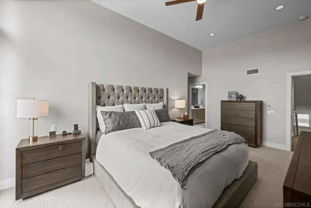 a bedroom with a bed and a lamp on a dresser