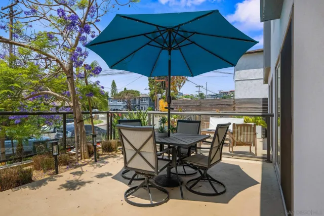 a view of a patio with furniture and table under an umbrella