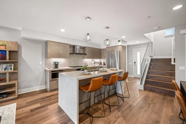 a kitchen with stainless steel appliances a stove a sink dishwasher and a refrigerator