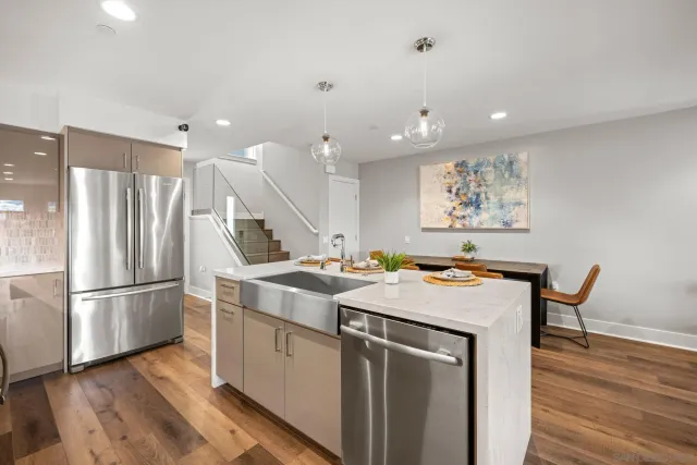 a kitchen with a stove a refrigerator and wooden floor