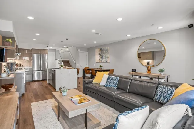 a living room with furniture and a view of kitchen