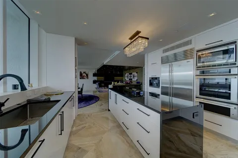 a kitchen with stainless steel appliances kitchen island granite countertop a stove and a refrigerator