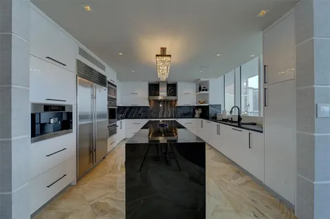 a large kitchen with kitchen island a sink stainless steel appliances and cabinets