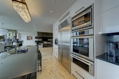 a kitchen with stainless steel appliances and chandelier