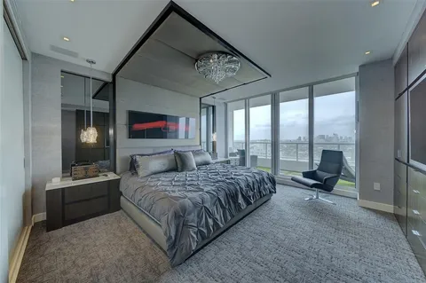 a bedroom with a bed and large windows