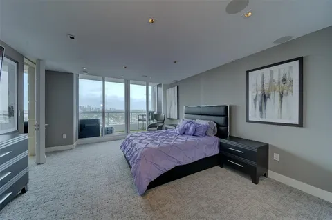 a spacious bedroom with a bed and large windows