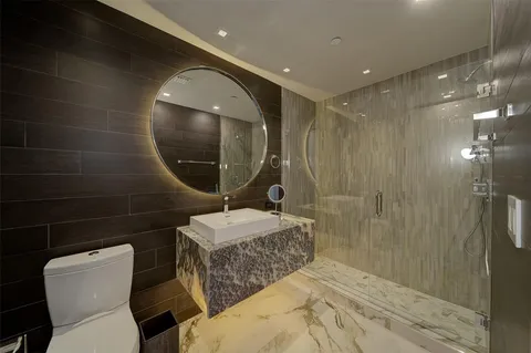 a bathroom with a double vanity sink mirror and toilet