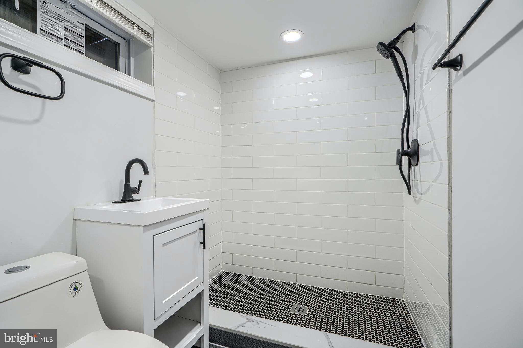 4400 Manorview Road Baltimore, MD 21229 - Photo 19 of 30 a bathroom with a sink a toilet and shower