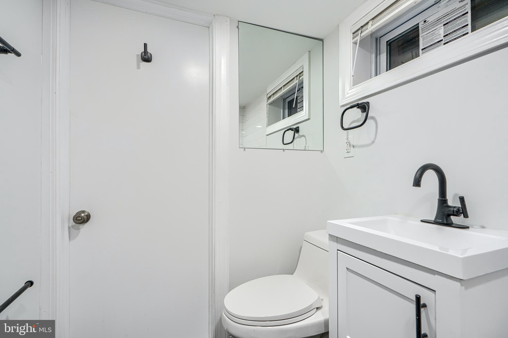 4400 Manorview Road Baltimore, MD 21229 - Photo 21 of 30 a bathroom with a toilet sink and mirror
