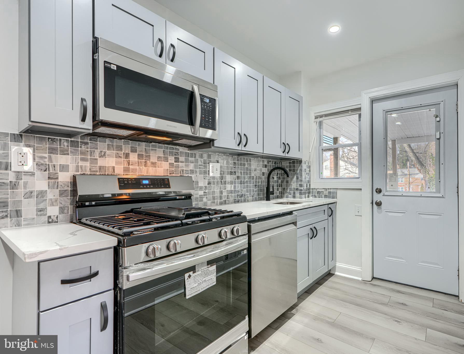 4400 Manorview Road Baltimore, MD 21229 - Photo 4 of 30 a kitchen with stainless steel appliances granite countertop a stove microwave and sink