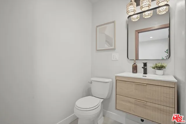 a bathroom with a toilet a sink a mirror and vanity