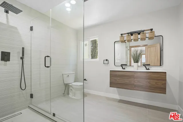 a bathroom with a double vanity sink mirror and shower