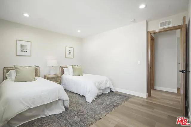 a bedroom with two beds and a lamp