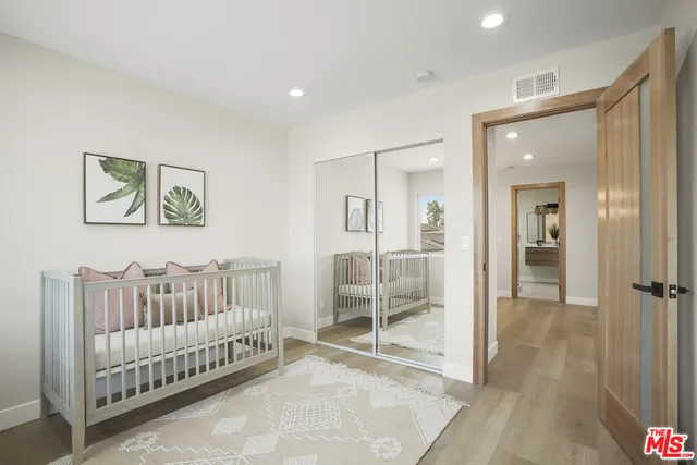 a view of a bedroom with wooden floor