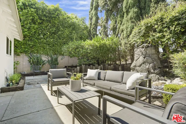 a view of a patio with couches and a large tree with wooden floor