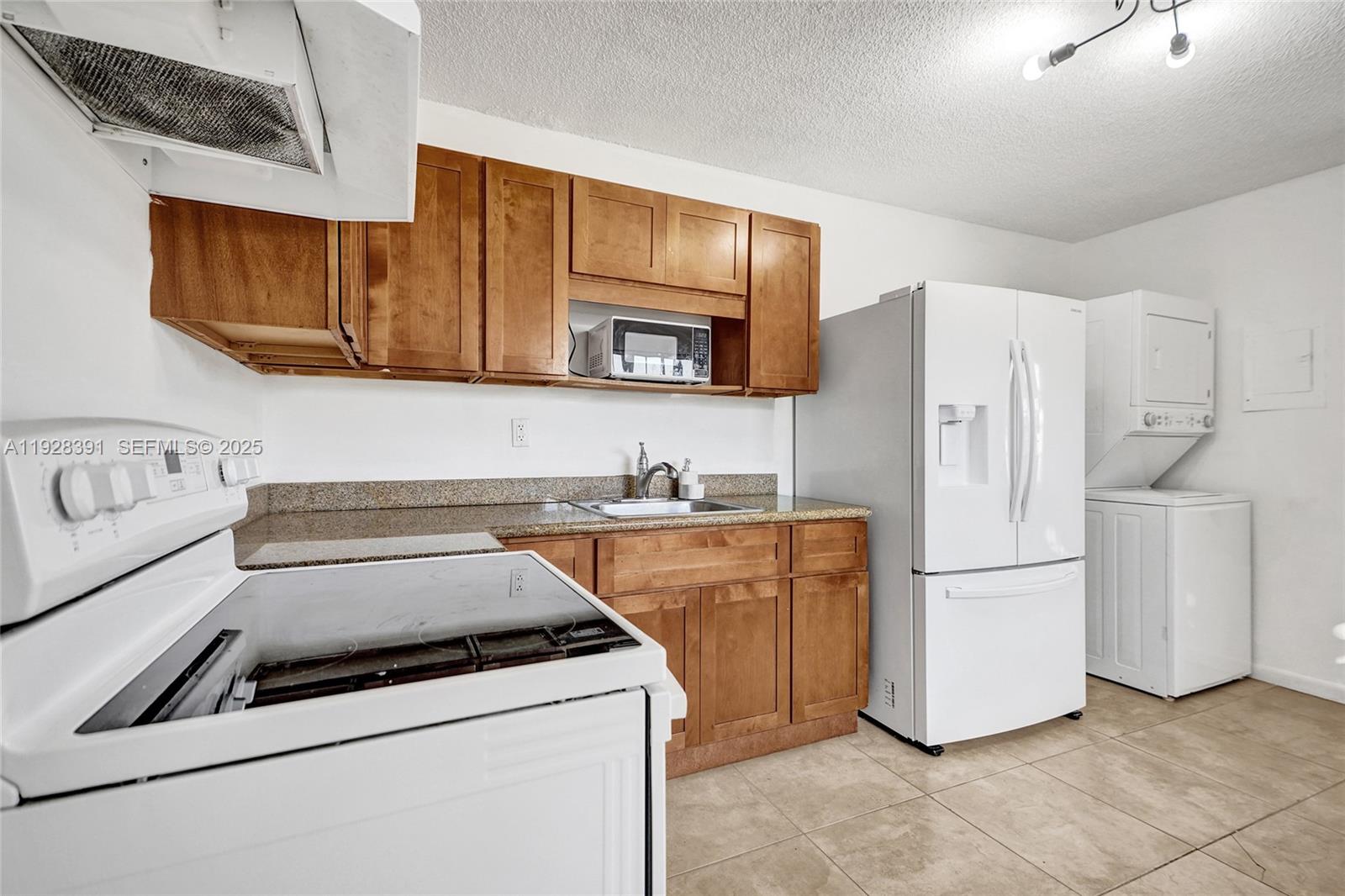 2907 Northwest 103rd Street, Unit 1 Miami, FL 33147 - Photo 13 of 38 a kitchen with a refrigerator sink and cabinets