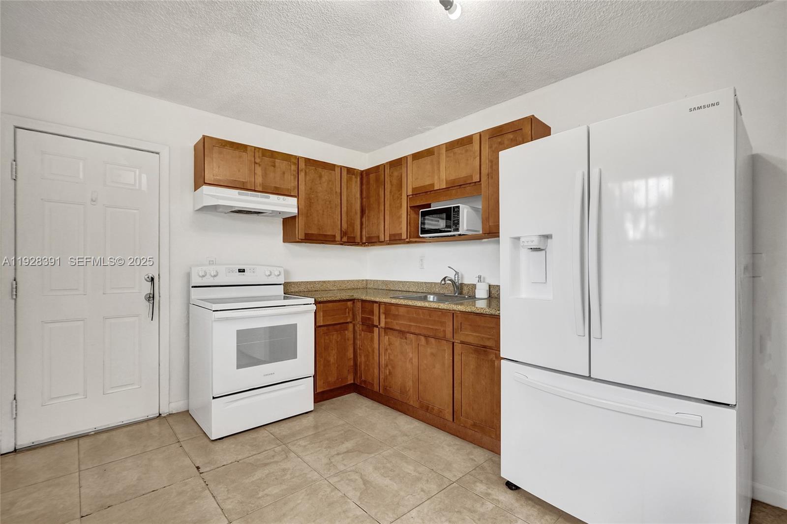 2907 Northwest 103rd Street, Unit 1 Miami, FL 33147 - Photo 14 of 38 a kitchen with stainless steel appliances granite countertop a refrigerator sink and stove