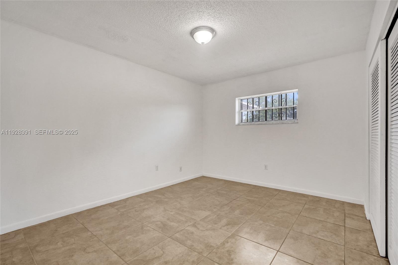 2907 Northwest 103rd Street, Unit 1 Miami, FL 33147 - Photo 19 of 38 an empty room with a window