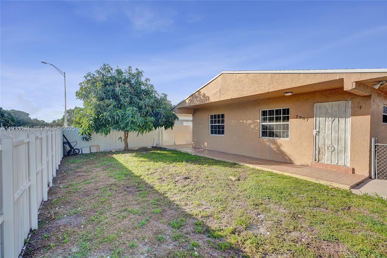 2907 Northwest 103rd Street, Unit 1 Miami, FL 33147 - Photo 30 of 38 a backyard of a house with plants and wooden fence