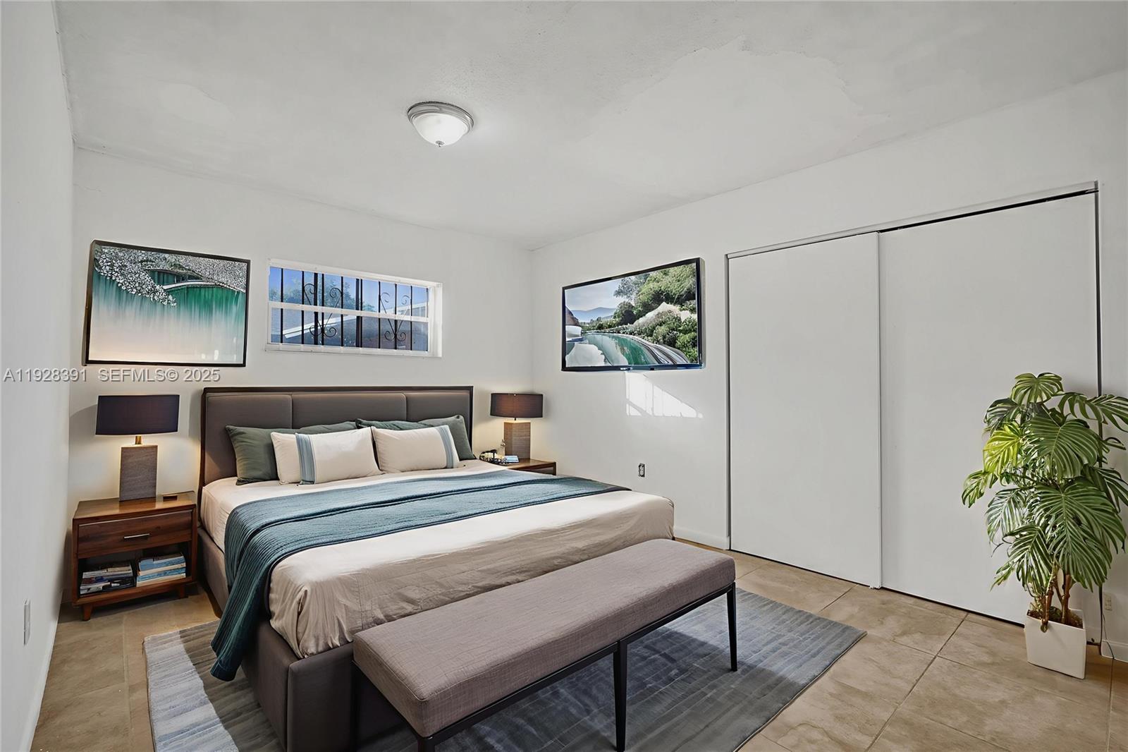 2907 Northwest 103rd Street, Unit 1 Miami, FL 33147 - Photo 3 of 38 a bedroom with a bed and a potted plant