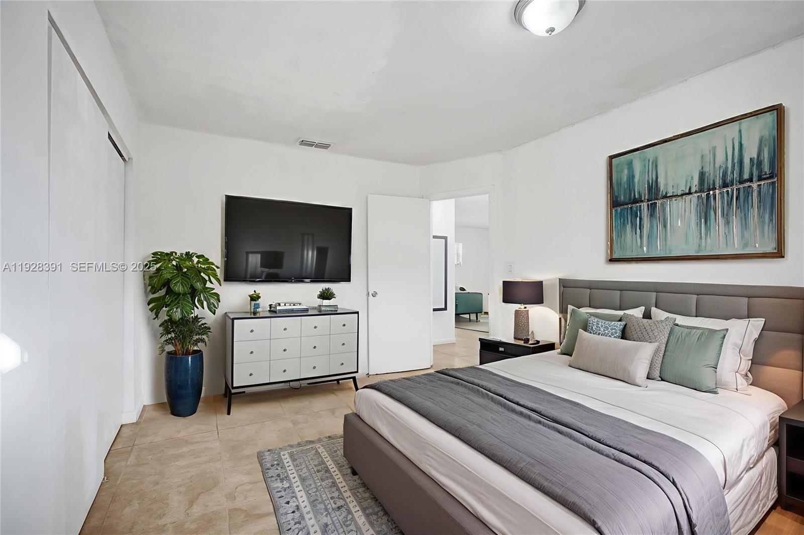 2907 Northwest 103rd Street, Unit 1 Miami, FL 33147 - Photo 4 of 38 a bedroom with a bed and a flat screen tv