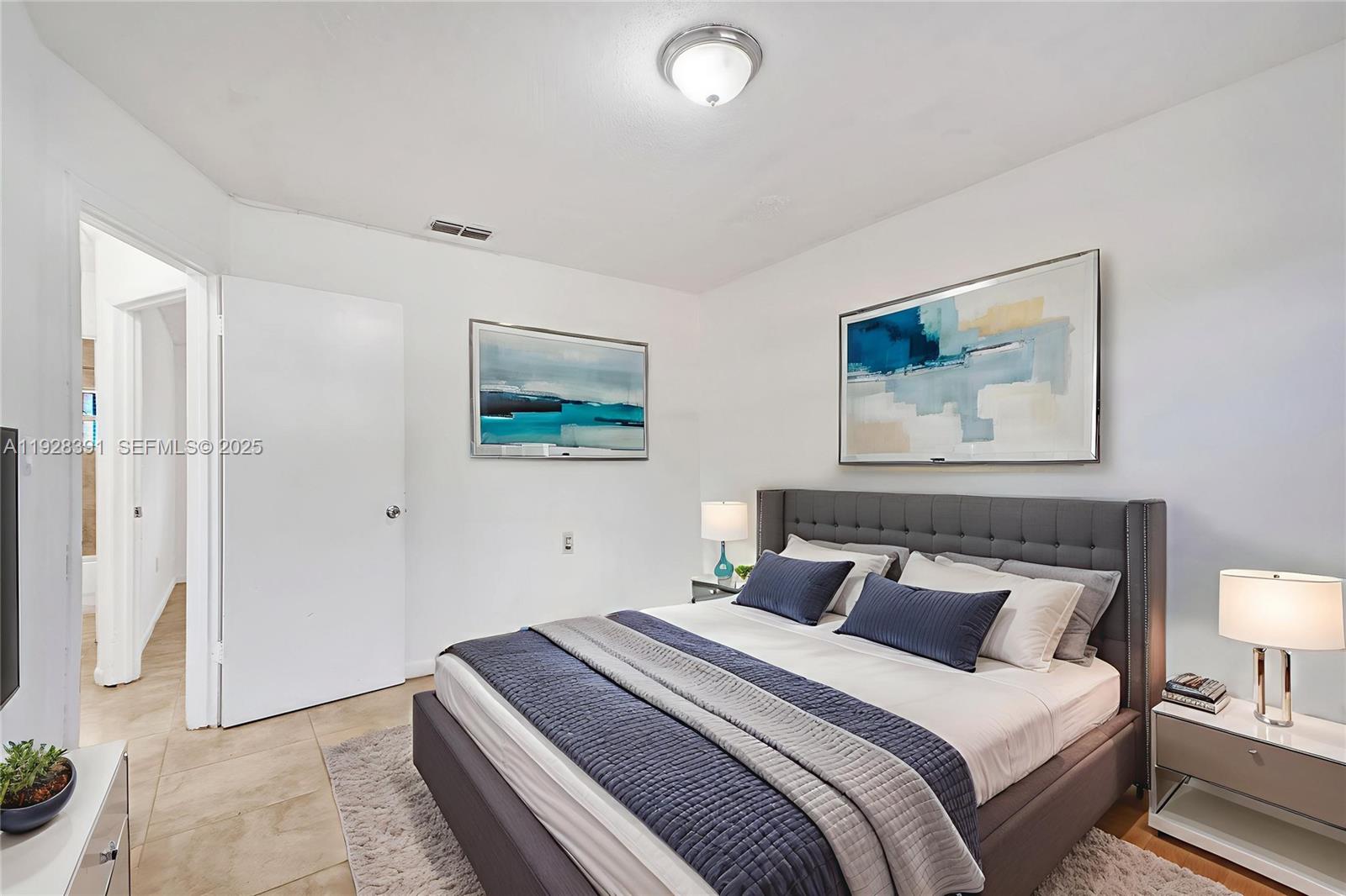 2907 Northwest 103rd Street, Unit 1 Miami, FL 33147 - Photo 6 of 38 a bedroom with bed and wall painting