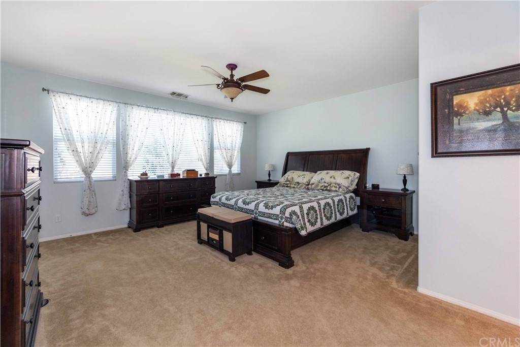 31271 Ensemble Drive Menifee, CA 92584 - Photo 12 of 30 a bedroom with a bed and a chandelier