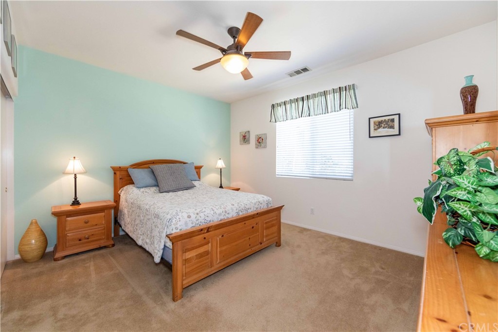 31271 Ensemble Drive Menifee, CA 92584 - Photo 16 of 30 a bedroom with a bed and a potted plant