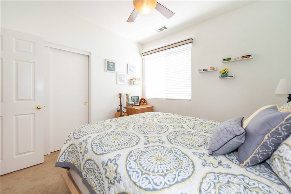 31271 Ensemble Drive Menifee, CA 92584 - Photo 20 of 30 a bedroom with a bed and a chandelier