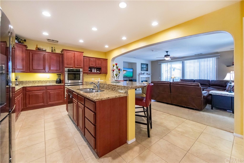 31271 Ensemble Drive Menifee, CA 92584 - Photo 3 of 30 a kitchen with stainless steel appliances granite countertop a stove a sink a oven and a refrigerator
