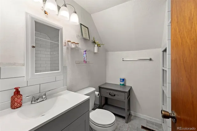 a bathroom with a sink vanity mirror and toilet