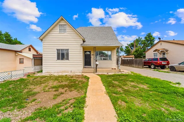 a yellow house with trees in front of it