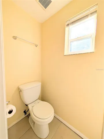 a white toilet sitting next to a bathroom sink and a window