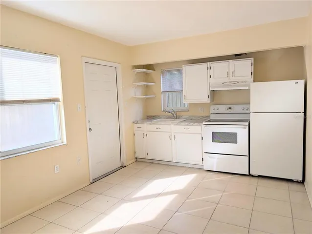a kitchen with a stove a sink dishwasher and a refrigerator