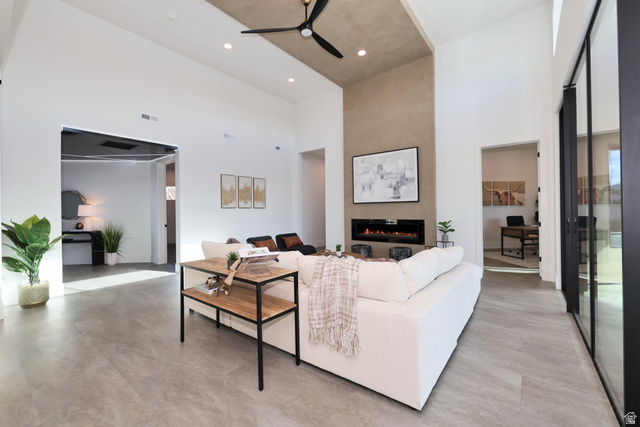 1306 East Victor Lane Draper, UT 84020 - Photo 10 of 60 Living room featuring a high ceiling, a ceiling fan, a fireplace, and concrete floors