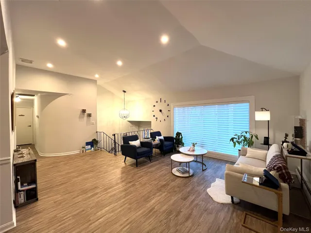 a living room with furniture wooden floor and a view of kitchen