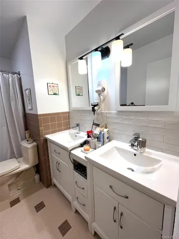a bathroom with a sink vanity mirror and toilet